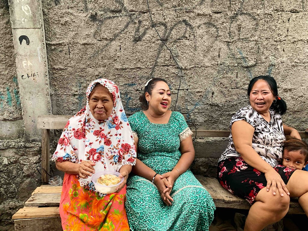Trois femmes discutant et riant sur un banc